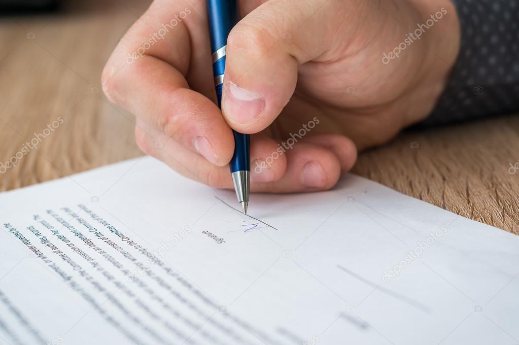 Person signing a consent form with mountains blurred behind