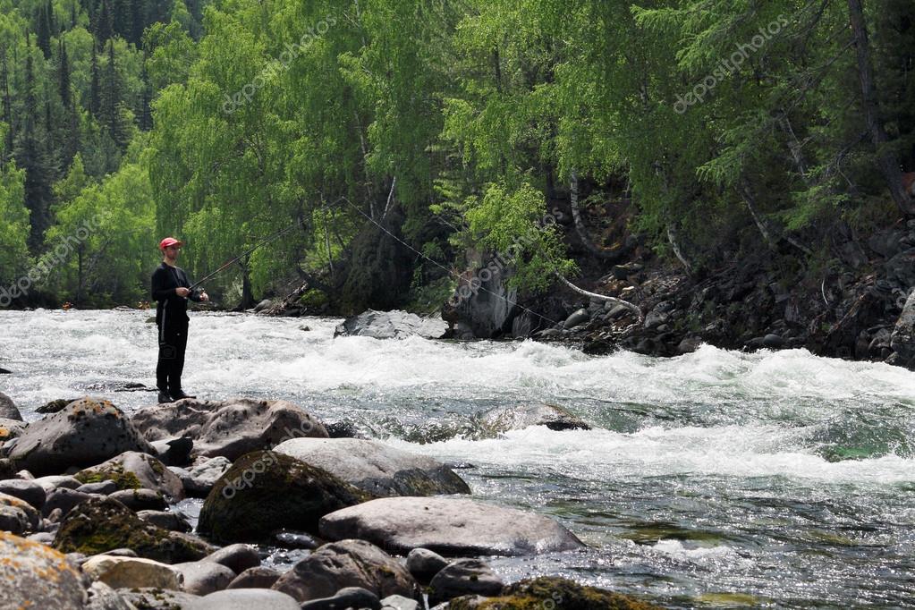Fly angler casting into a clear backcountry river