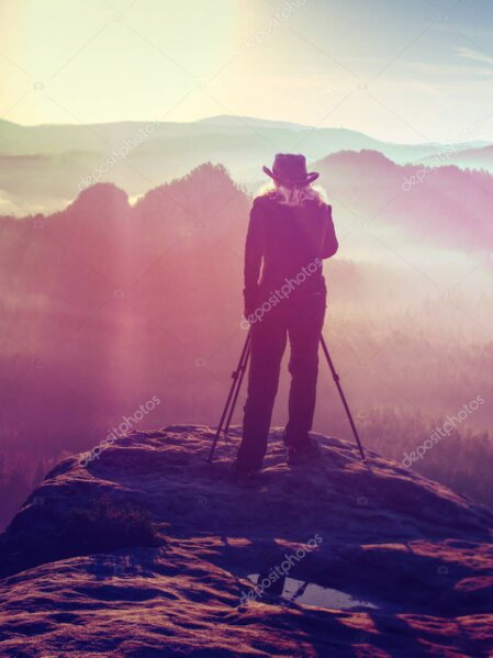 Guest taking photos of a couple on a mountain ridge with helicopter nearby