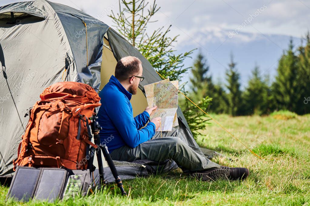 Guide planning a route with map in the mountains