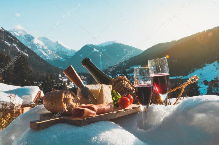 Guests enjoying a simple wilderness picnic on a grassy knoll above the valley.