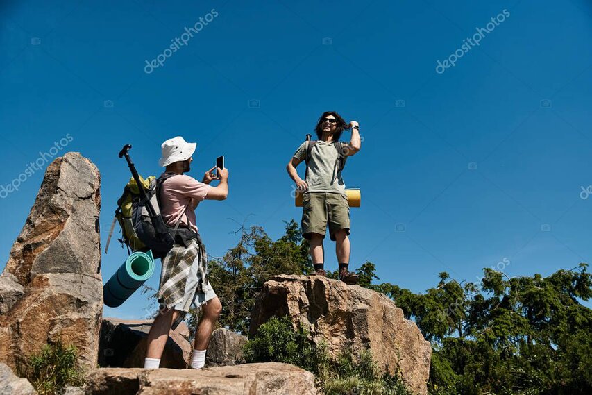Couple standing together on a viewpoint with mountains and lake behind.